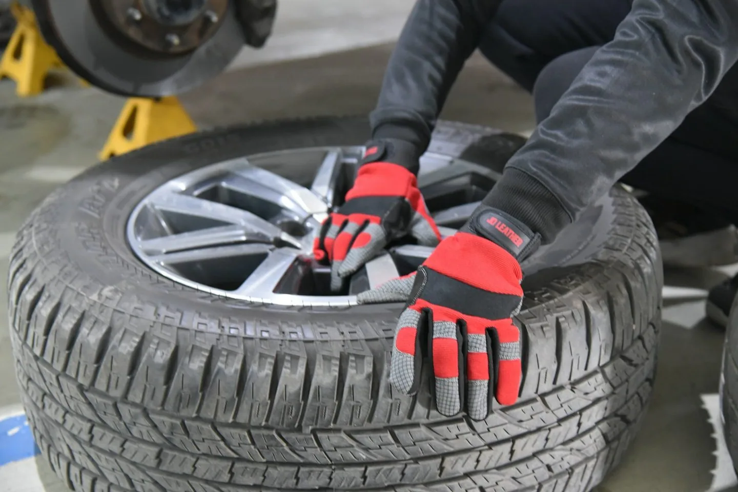 gloved hands fitting a tyre